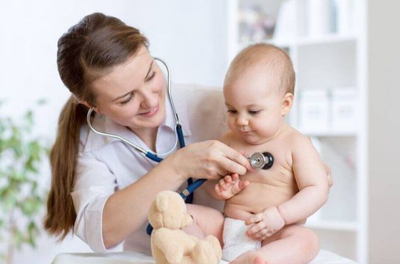 Une dermatologue examine la peau d’un enfant dans une salle colorée et accueillante à Rabat, avec des motifs marocains et des jouets visibles.