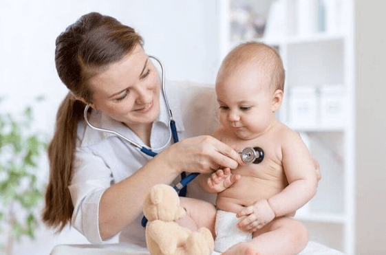 Une dermatologue examine la peau d’un enfant dans une salle colorée et accueillante à Rabat, avec des motifs marocains et des jouets visibles.