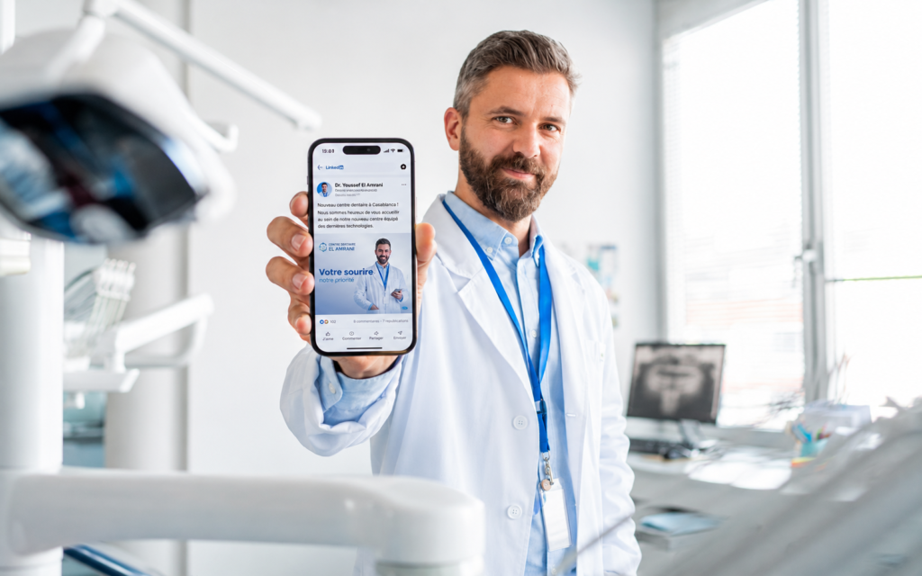Dentiste à Casablanca montrant une publication LinkedIn sur smartphone dans un cabinet moderne, illustration du marketing digital médical et de la communication pour médecins sociaux Maroc
